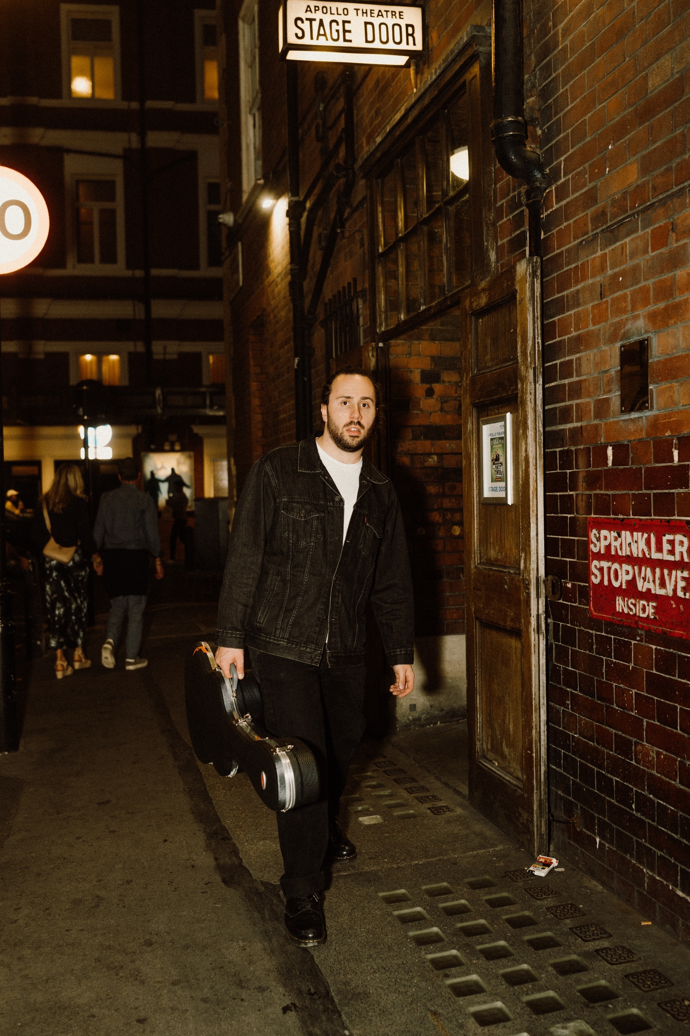 Connor Morel arriving at the stage door with a guitar case before a show